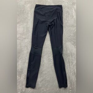 fitted black compression leggings w/ side pocket & zippers on bottom of ankles.